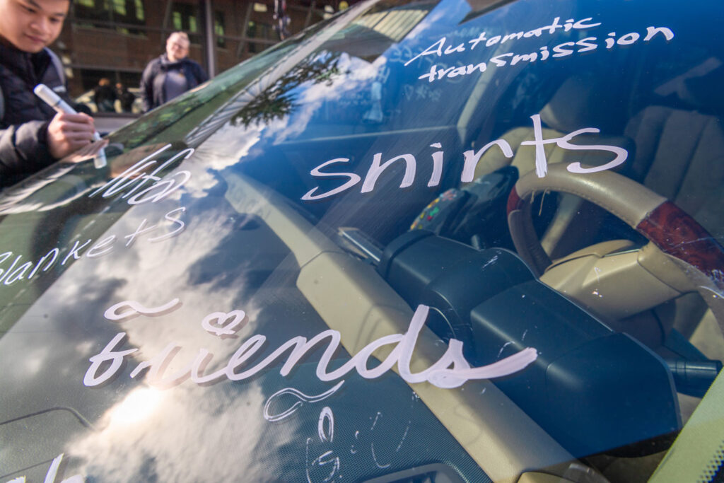 Writing on a car window reading: "Friends," "Shirts," "Automatic transmission" and "Blankets."